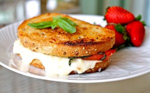 Grilled cheese sandwich with tomato and basil on sourdough bread. 